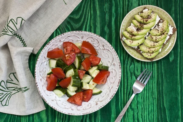 Sağlıklı bir salata taze domates ve sebze ve ev yapımı peynir sandviç, avokado ve baharat sert buğday tost. Sağlıklı bir kahvaltı.
