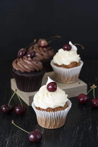 Heerlijke Chocolade Vanille Cupcakes Met Kersen Een Zwarte Achtergrond — Stockfoto