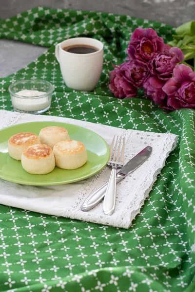美味的膳食芝士蛋糕从自制的农民奶酪早餐 黑咖啡和一束紫色郁金香在一个绿色的桌布 — 图库照片