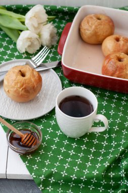 Elma kırmızı, beyaz fincan çay ya da kahve pişmiş, tatlım, bir sürü beyaz laleler yalan üzerine yeşil bir masa örtüsü.