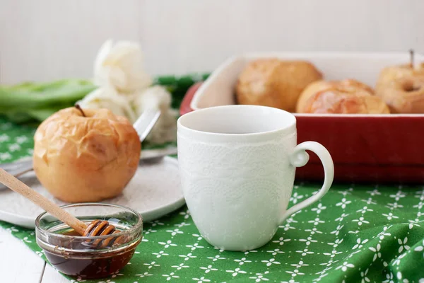 茶またはコーヒーの白いカップでリンゴを焼き 緑のテーブル クロスの上の白いチューリップの嘘の束 — ストック写真