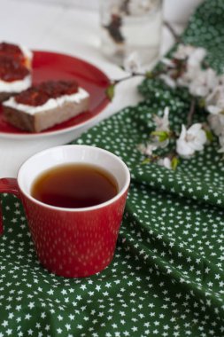 Yeşil peçeteye bir fincan siyah çay, ev yapımı çavdar ekmeği.