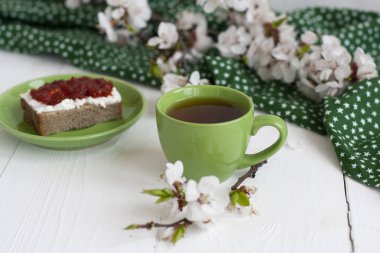 Yeşil peçeteye bir fincan siyah çay, ev yapımı çavdar ekmeği.