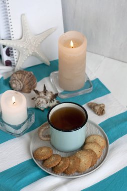 Çizgili bir masa üzerinde ev yapımı kurabiye ile siyah çay sıcak bir fincan