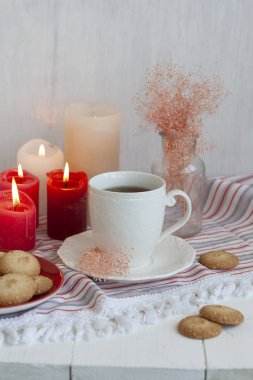 Çizgili bir masa üzerinde ev yapımı kurabiye ile siyah çay sıcak bir fincan