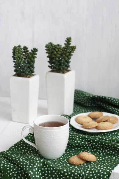 Filiżanka czarnej herbaty na zielonej serwetce, domowe ciasteczka — Zdjęcie stockowe