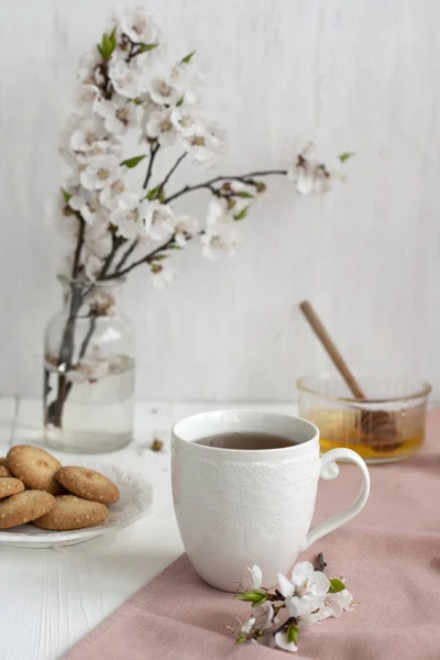 Una taza de té negro en una servilleta rosa, galletas caseras —  Fotos de Stock