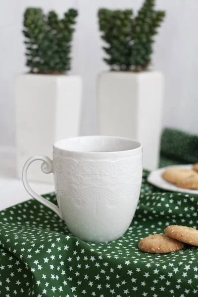 Una taza de té negro en una servilleta verde, galletas caseras — Foto de Stock