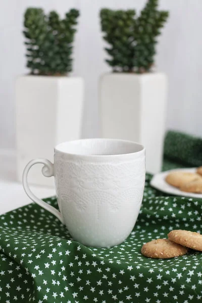 Uma xícara de chá preto em um guardanapo verde, biscoitos caseiros — Fotografia de Stock