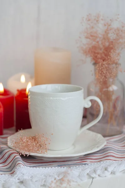 ストライプのテーブルクロス、ワックスキャンドル、紅茶の熱いカップ — ストック写真