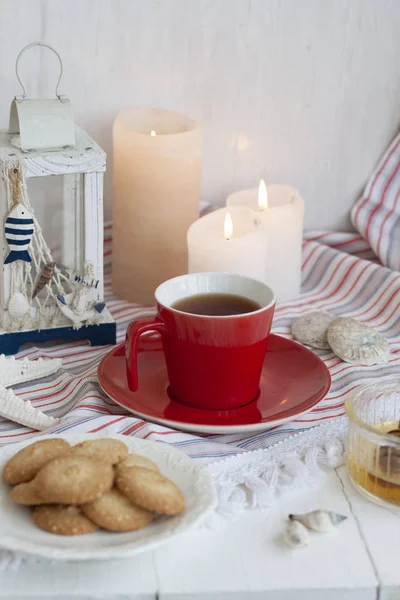 Une tasse de thé noir avec des biscuits faits maison sur une nappe rayée — Photo