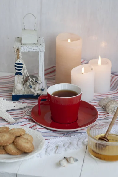 Чашка черного чая с домашним печеньем на полосатой скатерти — стоковое фото
