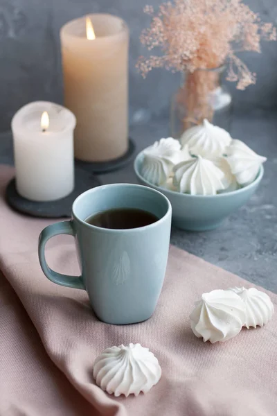 En varm kopp svart te med en skål med luftiga Marängar på en rosa t — Stockfoto