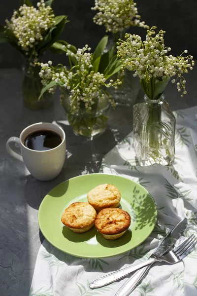 Um pequeno-almoço saboroso. Um prato de muffins recém-assados com um quente — Fotografia de Stock