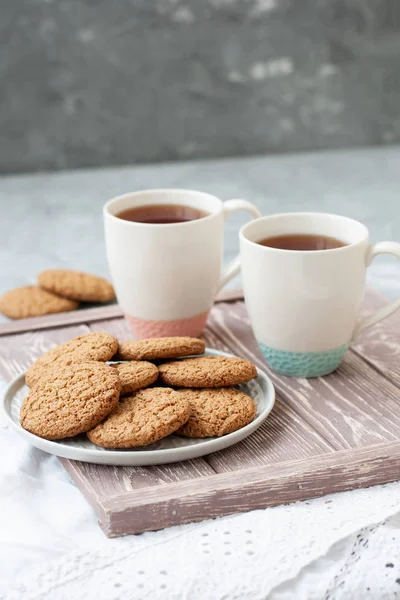 A tasty snack: two cups of tea and a plate of cookies. — Stock Photo, Image