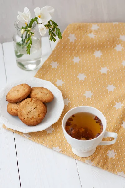 Ein leckerer Snack: eine Tasse Tee und ein Teller Kekse. — Stockfoto