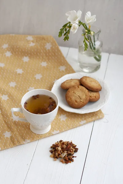 Un tentempié sabroso: una taza de té y un plato de galletas . — Foto de Stock