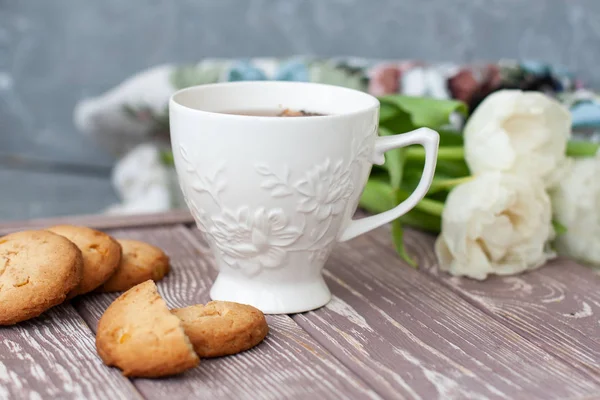 Ett välsmakande mellanmål: en kopp te och en bunt kakor. — Stockfoto