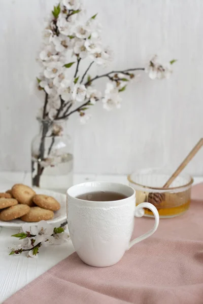 Uma pausa saborosa: uma xícara de chá e um prato de biscoitos . — Fotografia de Stock