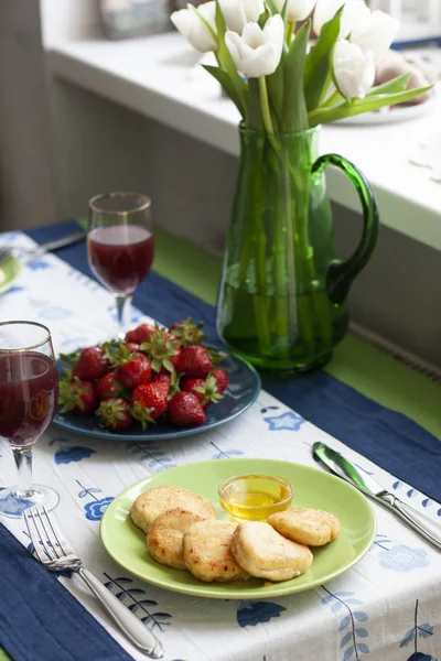Wykwintne śniadanie dla dwojga: syrnyky, truskawki, sok winogronowy — Zdjęcie stockowe