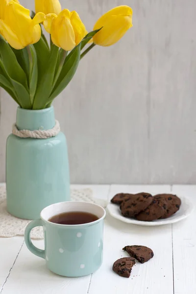 Un tentempié sabroso: una taza de té y un plato de galletas . —  Fotos de Stock