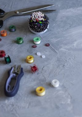 Bir örnekleme envanteri: düğmeler, iğneler, iplikler ve makas.