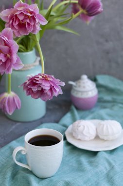 Lezzetli bir tedavi: bir fincan kahve ve marshmallow bir tabak.