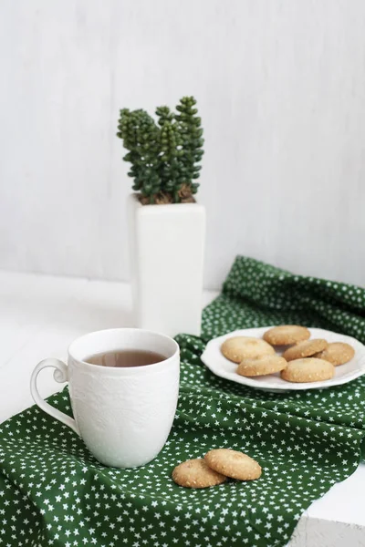 Een lekkere pauze: een kopje thee met een bordje koekjes. — Stockfoto