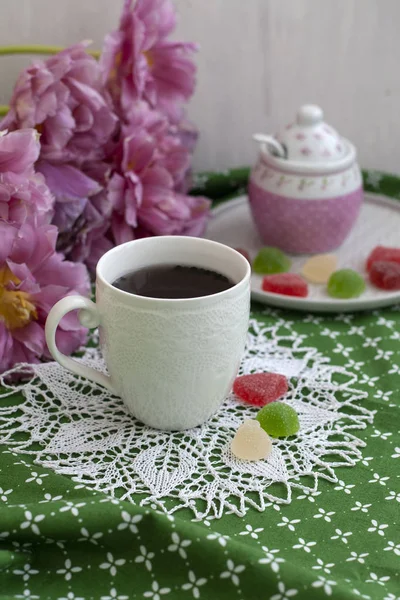 Un régal savoureux : une tasse de thé et une assiette de gelées de fruits . — Photo