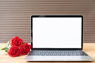 Kırmızı gül ve laptop mockup ahşap zemin, Sevgililer kavramı üzerine
