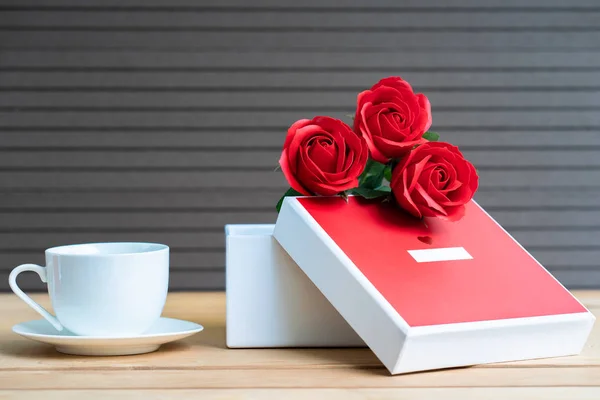 Close up red roses and gift box with coffee cup on wood background,Valentines Day concept with roses and red box
