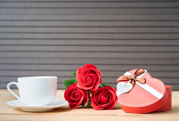 Close up red roses and gift box with coffee cup on wood background,Valentines Day concept with roses and red box