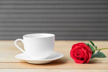 Ahşap arka planda kırmızı gül ve kahve fincanı, Sevgililer Günü konsepti