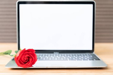 Kırmızı gül ve laptop mockup ahşap zemin, Sevgililer kavramı üzerine