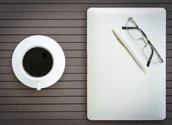 Top view coffee time , Office desk table with laptop,notebook, coffee cup,glasses