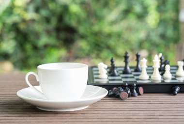 Kahve fincanları masada, satranç tahtası ve gevşemek için parçalar.