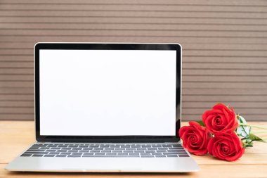 Kırmızı gül ve laptop mockup ahşap zemin, Sevgililer kavramı üzerine