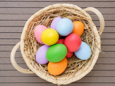 Sepet alanı olan ahşap arka plan üzerinde renkli Paskalya yumurta kadar kapatın