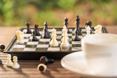 Kahve fincanları ahşap masada, satranç tahtası ve parçaları dinlenmek için.