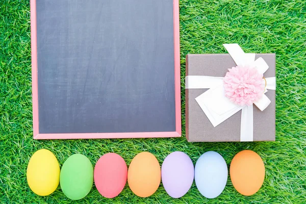 Fechar ovos de Páscoa na grama e blackboard mockup — Fotografia de Stock