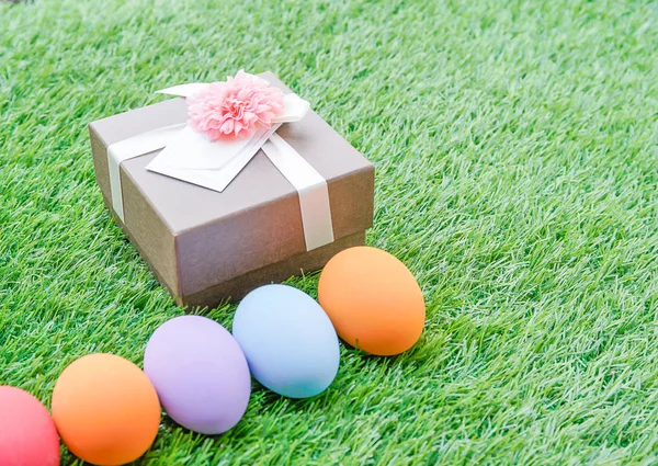 Huevos de Pascua en hierba y caja de regalo —  Fotos de Stock