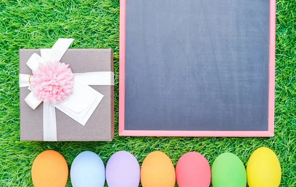 Cerrar los huevos de Pascua en la hierba y pizarra maqueta —  Fotos de Stock