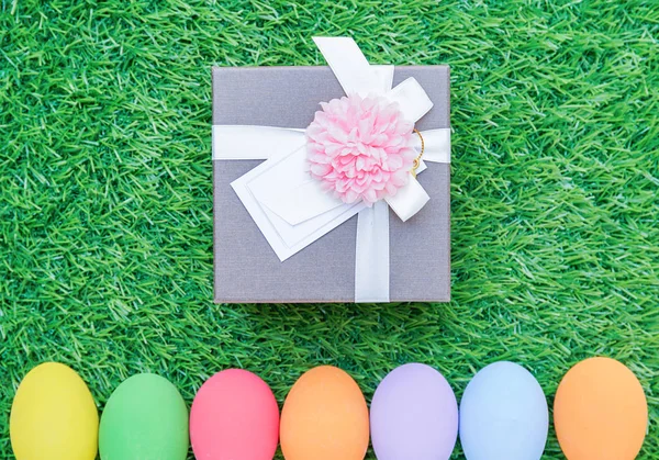 Huevos de Pascua en hierba y caja de regalo —  Fotos de Stock