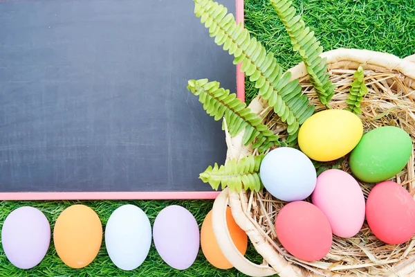 Cerrar los huevos de Pascua en la hierba y pizarra maqueta —  Fotos de Stock