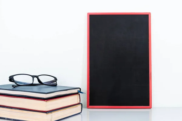 Chalkboard mock up frame and old books with eyeglasses — Stock Photo, Image