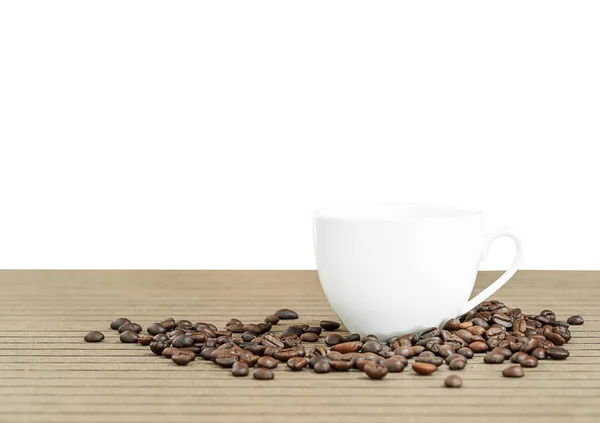 Grãos de café em xícara de café em branco — Fotografia de Stock