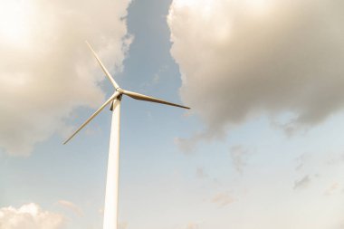 Wind turbine against a cloudy blue sky