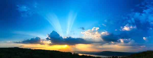 Panorama Sunset with ray light on clouds in a blue and orange sky in twilight time
