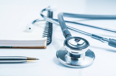 Tıbbi steteskobu kapatın. Tıbbi konsept olarak not defteriyle sağlık laboratuarı masasını kontrol edin.