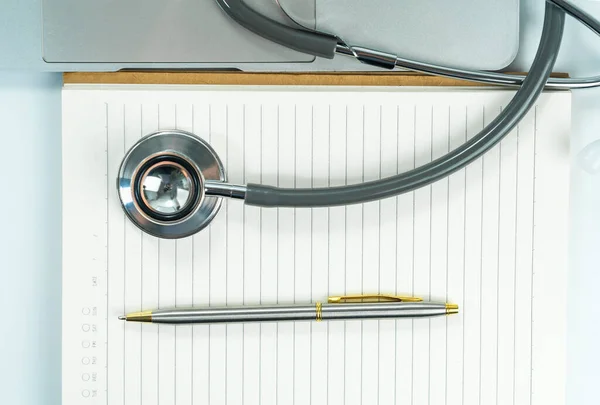 Medical stethoscope for doctor checkup on notepad as medical concept